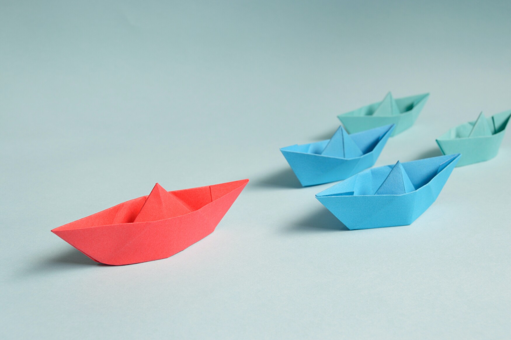 Set of boats led by large red boat